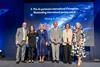 Staff from Visions in Education stand on stage at an awards event