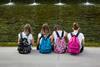 Girls with colorful Backpack Seated in front of Fountain