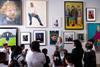 A class in front of a wall of portraits during a guided session