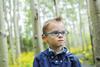 A young boy wearing a hearing aid in the woods
