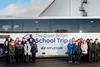School children in front of a coach with Hyundai's The Great British School Trip programme branding along with Apprentice winner Sir Tim Campbell MBE.