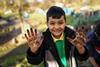 A boy with muddy hands taking part in an activity as part of the Waterways, Wildlife and Wellbeing project