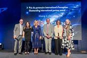 Staff from Visions in Education stand on stage at an awards event