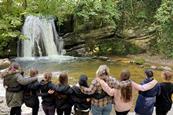 A group of students look at a waterfall