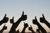 Silhouette of people's hands with thumbs up
