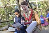 School child discussing animals at London Zoo with a teacher during educational visit