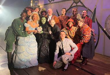 The West End cast of Wicked pose with their School Travel Award on stage at the Apollo Victoria Theatre