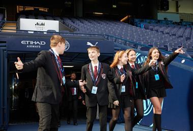 Pupils walking through the tunnel and into the dugout at Manchester City Football Club's Etihad Stadium