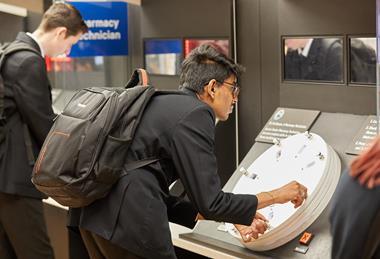 Student leans over interactive exhibit in museum