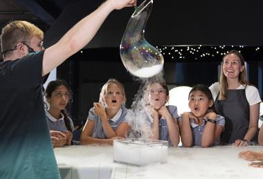KS2 group watching a live experiment at the Chemistry Bar in Wonderlab, Science Museum.