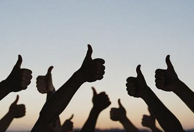 Silhouette of people's hands with thumbs up