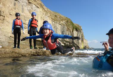 Child jumping into the sea at Land & Wave in Dorset