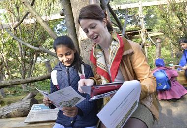 School child discussing animals at London Zoo with a teacher during educational visit