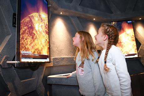 Two girls look on at news footage in awe as part of National Space Centre's Mission to Mars