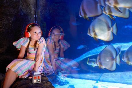 Girl with headset looking into underwater exhibit