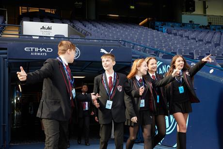 Pupils walking through the tunnel and into the dugout at Manchester City Football Club's Etihad Stadium