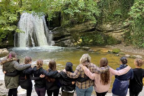 A group of students look at a waterfall