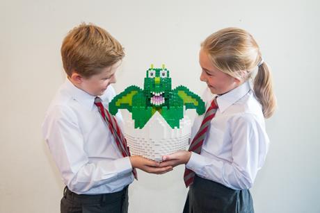 Two children hold a dragon lego model during a school visit to Legoland Windsor Resort