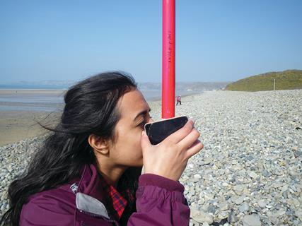 A student carries out a survey on a beach for the Field Studies Council