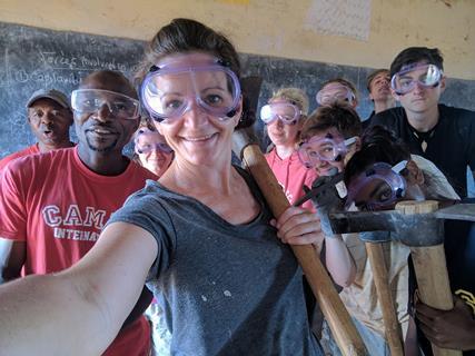 Adults and students helping with building work during an expedition.