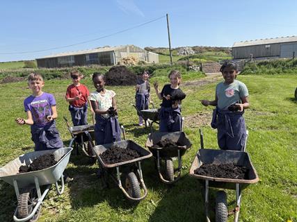 St Woolos Primary School students with wheelbarrows at Treginnis Farm