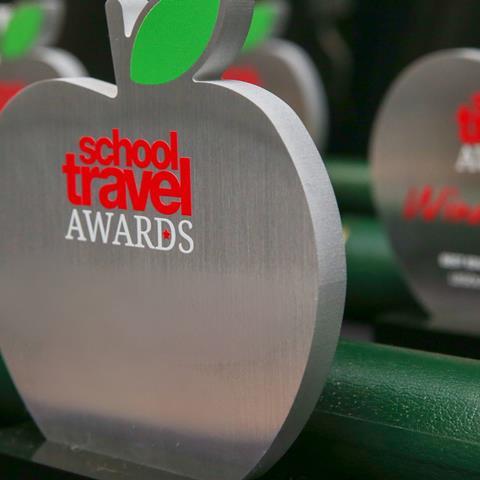School Travel Awards trophies lined up on a table.