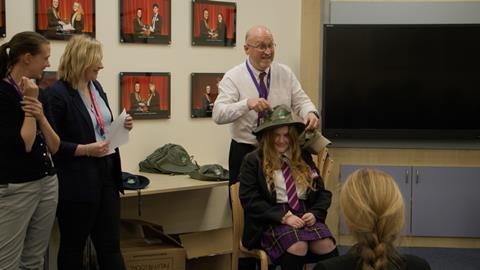 Jon Clarke, Walsall Academy's shadow headteacher, gives one of the students their Borneo team hat