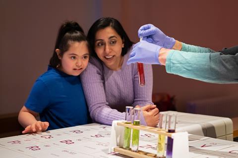 A family engaging with test tube demo within Wonderlab