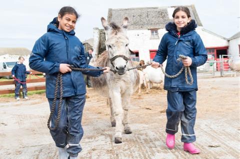Two school children seen walking a donkey at Farms for City Children's Lower Treginnis farm in Pembrokeshire