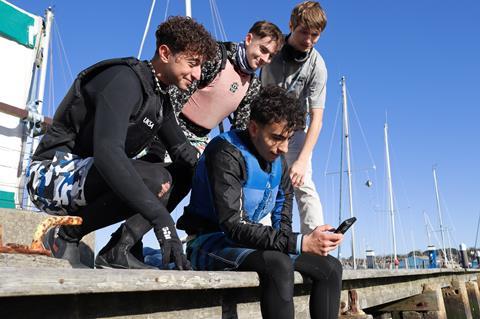 A group of UKSA students look at a phone