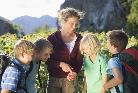 Teacher explaining a compass to boys