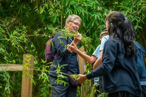 A member of staff at Wakehurst botanic garden with school students