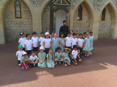 Key Stage 1 pupils from Deanesfield School stand with a guard at Windsor Castle