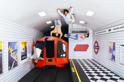 People upside down in a set designed to look like a London tube platform