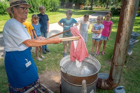 Children watch a demonstration at the Black Forest Open Air Museum, Germany