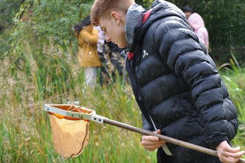A teenager carries out pond dipping during a Field Studies Council visit