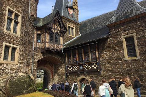 Students being led through an archway of an old building