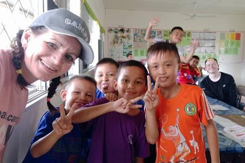 A woman with a group of happy children.