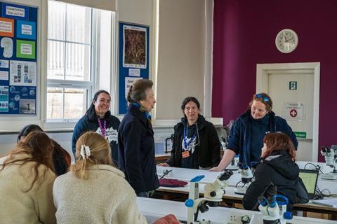 Princess Anne talks with a group of students and staff in a laboratory