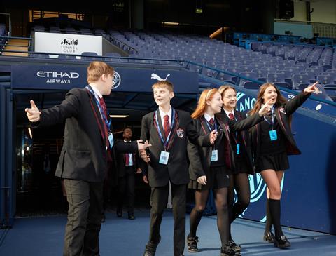 Pupils walking through the tunnel and into the dugout at Manchester City Football Club's Etihad Stadium