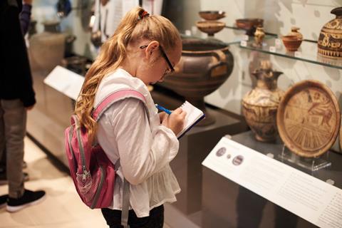 Child at the museum taking notes