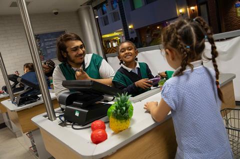 Students at KidZania London have a go at working in a supermarket.