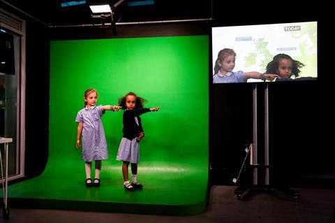 Two pupils at KidZania London learn how to present the weather forecast.