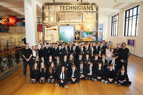 A group of students pose for a photo in front of a large gallery exhibit