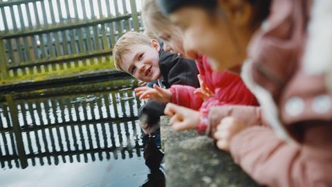 Children peer into the water - they're illustrating the offer from the Council for Learning Outside the Classroom which is giving away free membership to schools and educational settings
