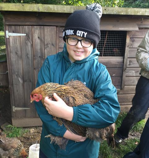 Student holding a chicken at Nethercott House