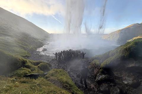 Group of people in front of exploding geyser