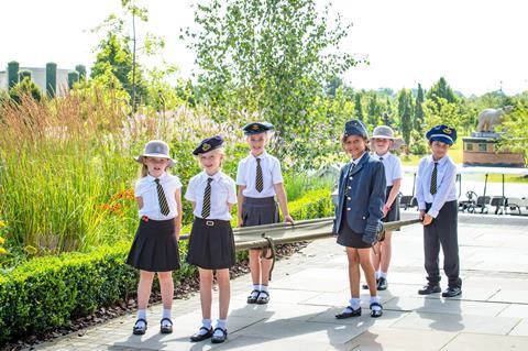 School children carrying a stretcher whilst visiting the National Memorial Arboretum