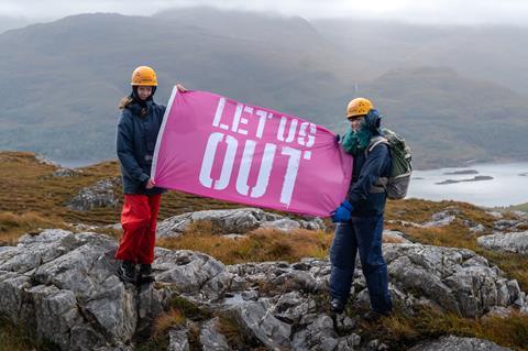 A group of young people hold banners and flags supporting the Let Us Out campaign to make outdoor residentials part of the school curriculum