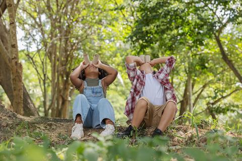 Children with pretend binoculars in the woods